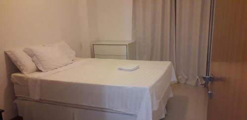 um quarto com uma cama com uma colcha branca em Privileg em Ilhéus