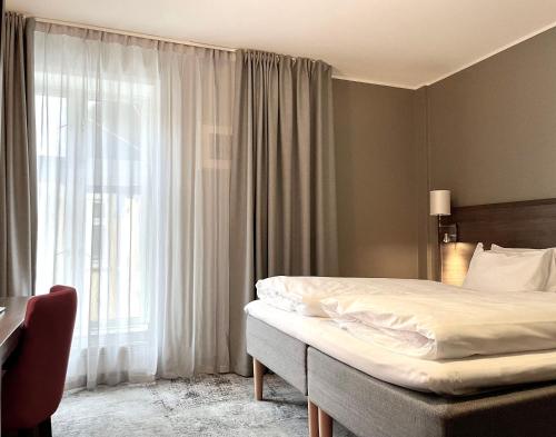 a bedroom with a bed and a large window at Karl Johans gate 35 in Oslo