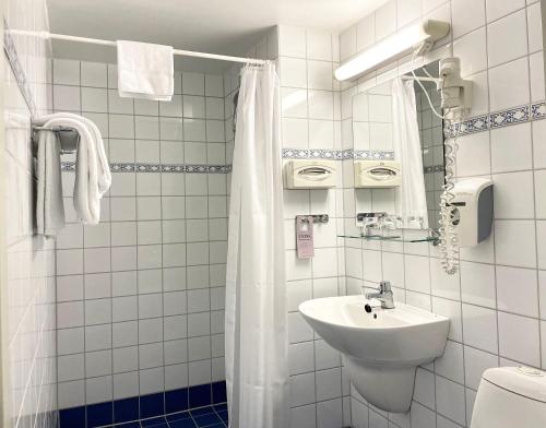 a white bathroom with a sink and a toilet at Karl Johans gate 35 in Oslo