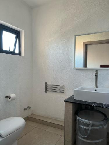 a bathroom with a sink and a toilet and a mirror at Ibis Tourist Residence 1 in Mahébourg