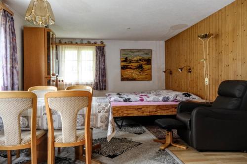1 dormitorio con 1 cama con sillas y mesa en Ferienwohnung Lenk, en Lenk
