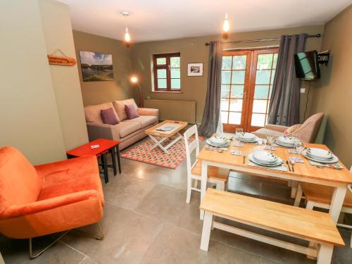 a living room with a table and a dining room at Bwthyn Canol in Haverfordwest