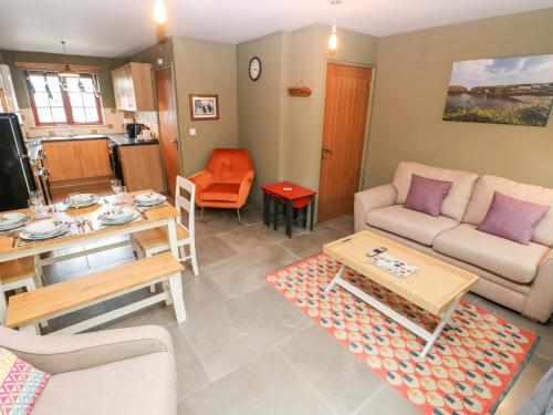 a living room with a couch and a table at Bwthyn Canol in Haverfordwest