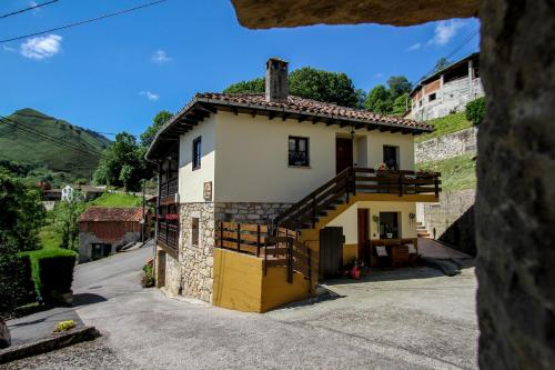 una pequeña casa con una escalera delante en Apartamentos Los Balcones de Nieda 1, en Cangas de Onís