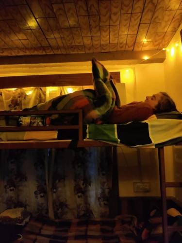 a man laying on top of a bunk bed at Ikigai Manali in Nagar
