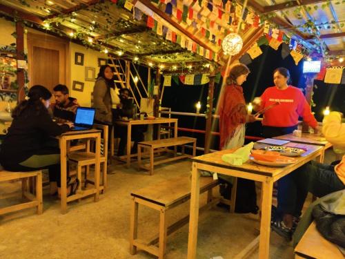 a group of people sitting at tables in a restaurant at Ikigai Manali in Nagar
