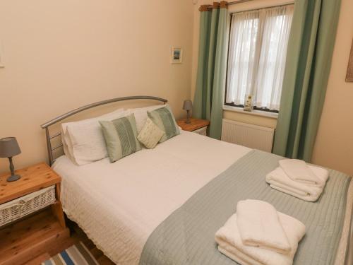 a bedroom with a bed with two towels on it at 2 Chandlers Yard in Burry Port