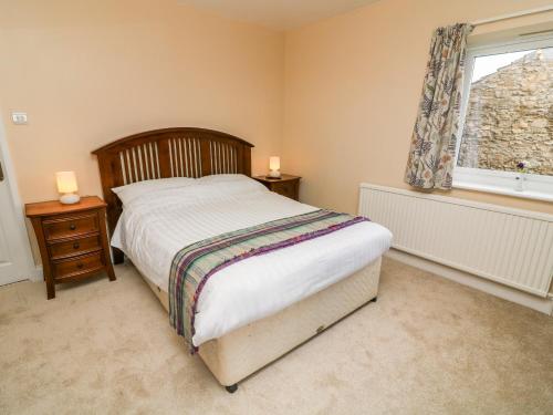 a bedroom with a bed and a window at Keartons - Buttertubs in Richmond