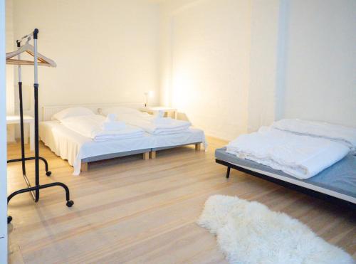 a bedroom with two beds and a rug at Copenhagen City Flat -cosy backyard & vibrant area in Copenhagen