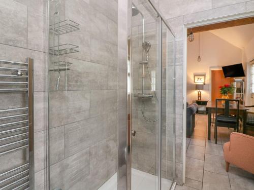 a bathroom with a shower with a glass door at Willow Cottage in Aberystwyth