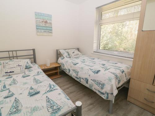 2 camas individuais num quarto com uma janela em Ballasalla em Liskeard