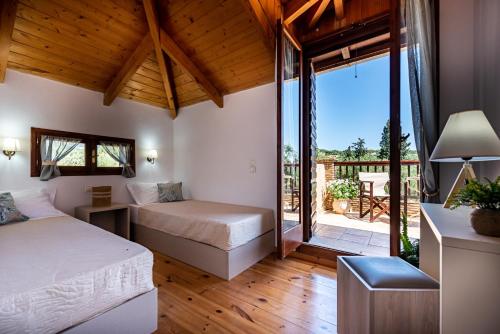 a bedroom with two beds and a balcony at Casa Koukounaria in Lithakia