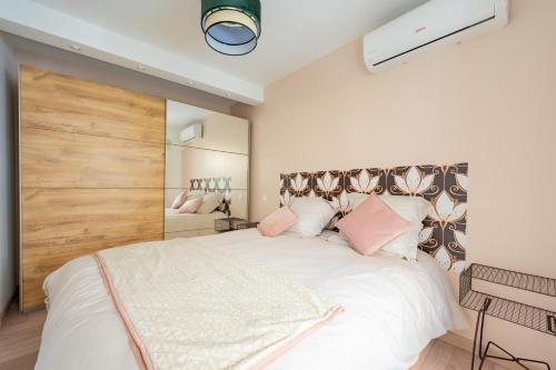 a bedroom with a large white bed with pink pillows at Novaä in Antibes