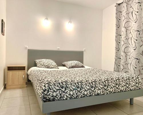 a bedroom with a bed and two pillows on it at Le Mas des Bois in Le Muy