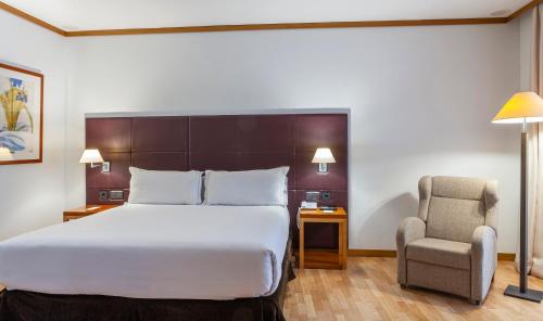 a hotel room with a bed and a chair at Senator Parque Central in Valencia
