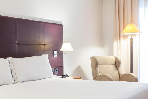 a hotel room with a bed and a chair at Senator Parque Central in Valencia