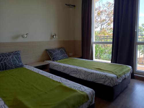 2 Betten in einem Zimmer mit Fenster in der Unterkunft вила ФЛОРА in Tschernomorez