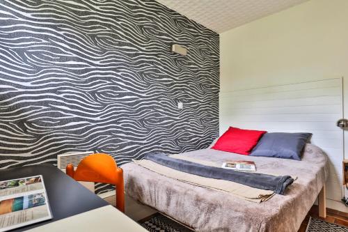 a bedroom with a bed and a patterned wall at La Presque Basque in Labenne