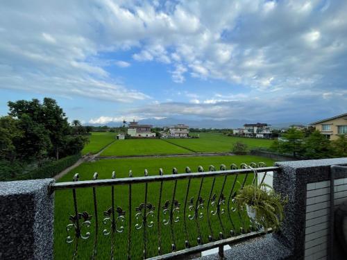 a balcony with a view of a green field at 根本町無印風Villa包棟寵物友善 朋友聚會 烤肉廚房 兒童友善 in Yilan City