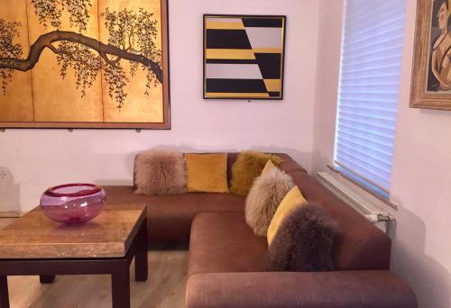 uma sala de estar com um sofá castanho e uma mesa em Zentrales Apartment -Am Stadtpark- em Wittenberg