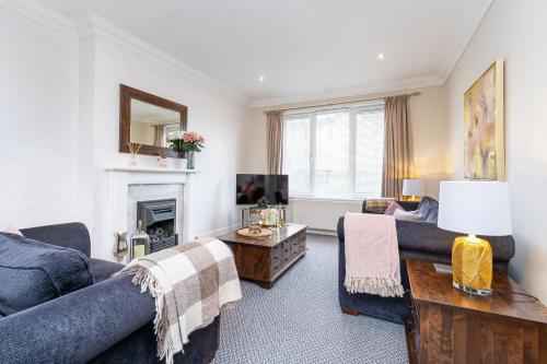 a living room with a couch and a tv at NEW Four Bedroom House - all rooms ensuite in Stirling