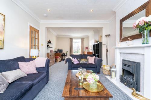 a living room with a couch and a fireplace at NEW Four Bedroom House - all rooms ensuite in Stirling