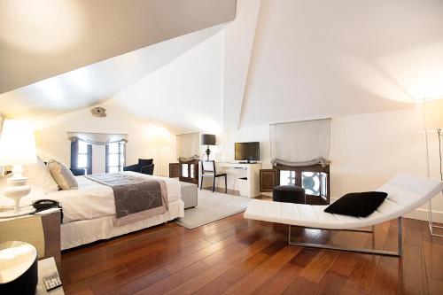 a bedroom with a bed and a living room at Hospes Palacio de los Patos, a Member of Design Hotels in Granada