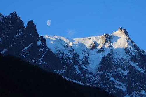a snow covered mountain with a blue sky in the background at Chalet Pleine Vue & Spa in Chamonix-Mont-Blanc