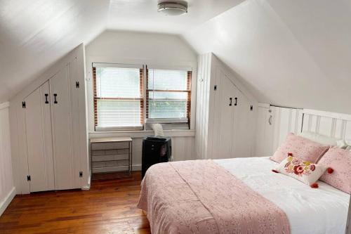 a white bedroom with a bed and a window at Grandma's Attic in Lakewood