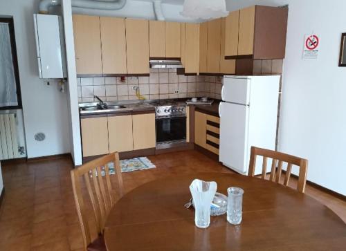 uma cozinha com mesa e cadeiras e uma cozinha com electrodomésticos brancos em Appartamento piario em Nasolino