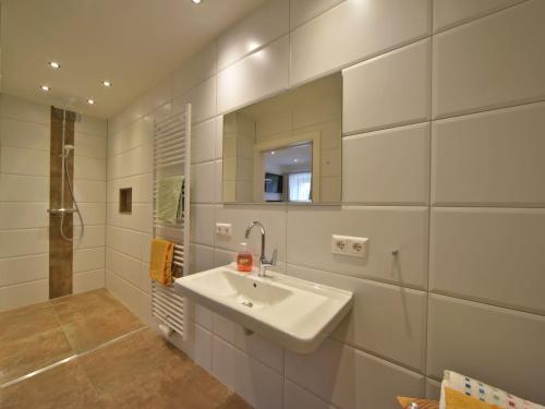 Landhaus Ebner في ميلستاف: حمام أبيض مع حوض ومرآة