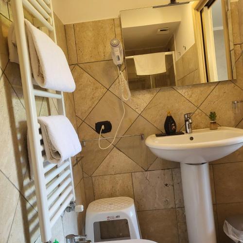 a bathroom with a sink and a toilet and a mirror at Rainbow Sweet Rooms in Valmontone