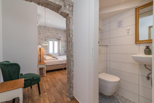 a bathroom with a toilet and a bed in a room at Residence Providenca in Trogir