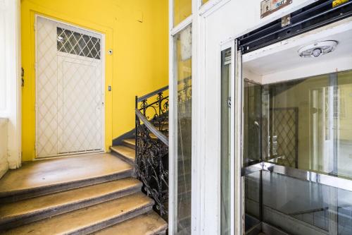 una entrada a una casa con puerta amarilla en ELISABETH 50 AIRCON DOWNTOWN APARTMENT, en Budapest