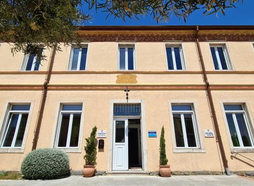 a large brick building with a white door at Hotel Stara šola - Oleander Resort in Izola