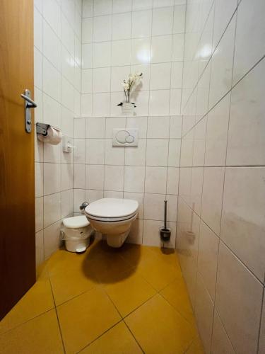 a bathroom with a toilet and a flower on the wall at Appart Kofler in Gerlos