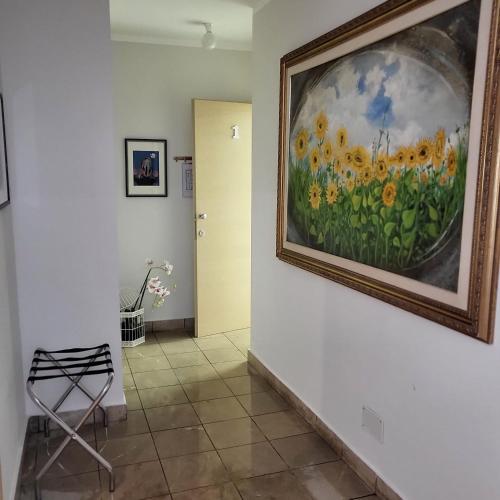 a painting of a field of flowers on a wall at Rainbow Sweet Rooms in Valmontone