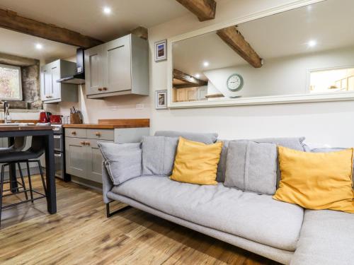 a living room with a couch and a kitchen at 2A Chiserley Stile in Hebden Bridge