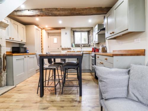 a kitchen with a table and chairs in a room at 2A Chiserley Stile in Hebden Bridge