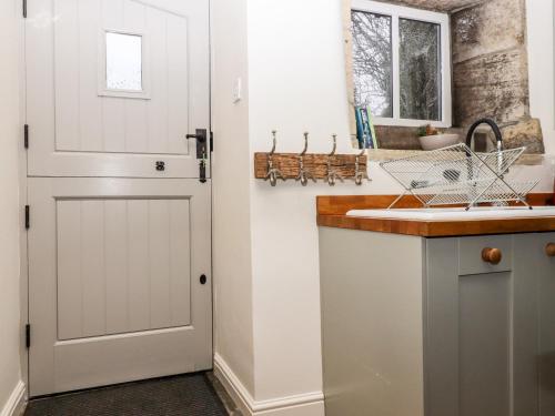 a kitchen with a white door next to a sink at 2A Chiserley Stile in Hebden Bridge