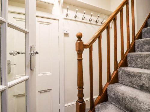 a hallway with a white door and stairs at 2A Chiserley Stile in Hebden Bridge
