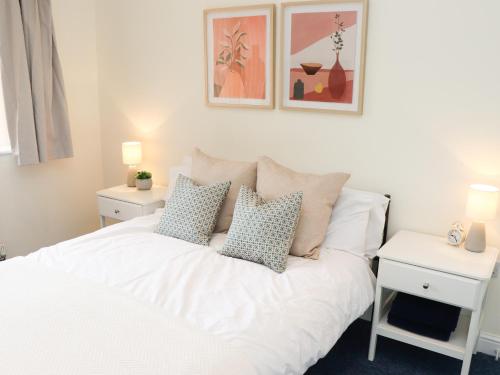 a bedroom with a white bed with pillows on it at Copse View in Lincoln