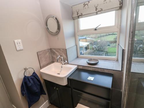 a bathroom with a sink and a window at Stable Cottage in Barnard Castle