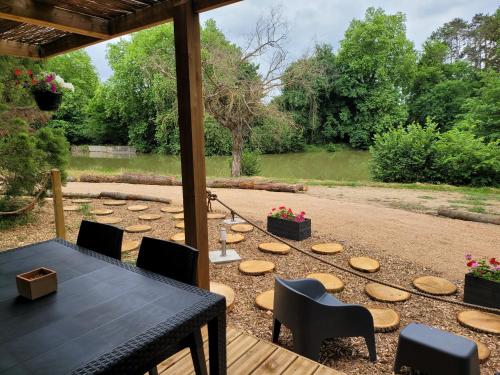 a patio with a table and chairs and a garden at Le Chalet Montégut in Moulins