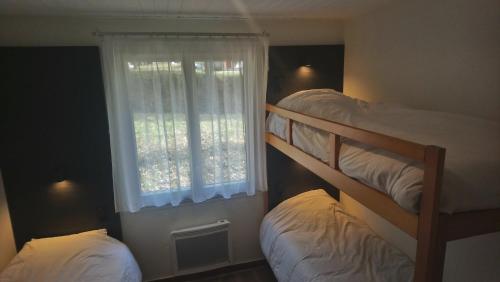 2 Etagenbetten in einem Zimmer mit Fenster in der Unterkunft Résidence de Tourisme LE VENDAHAUT in Lapleau