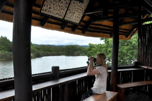 a woman taking a picture of a river at Legend Safaris 257A - in Kruger Park Lodge in Hazyview