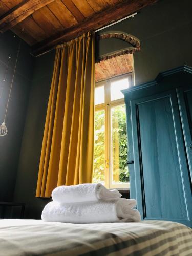 a bedroom with a bed and a window with yellow curtains at Casa Conte Rosso in Avigliana