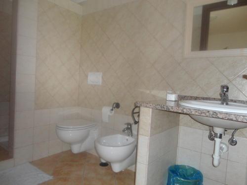 a bathroom with a toilet and a sink at Agriturismo Gavina Pes in Campanedda