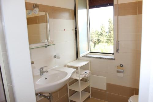 a bathroom with a sink and a window at Hotel Conca d'Oro in Stalettì
