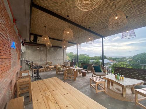 a restaurant with tables and chairs and a large window at Shorebreak Hostel San Juan La Union in san juan la union